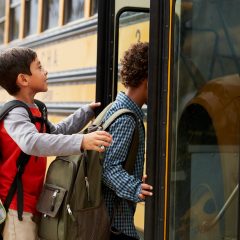 Elementary school kids climbing on to a school bus